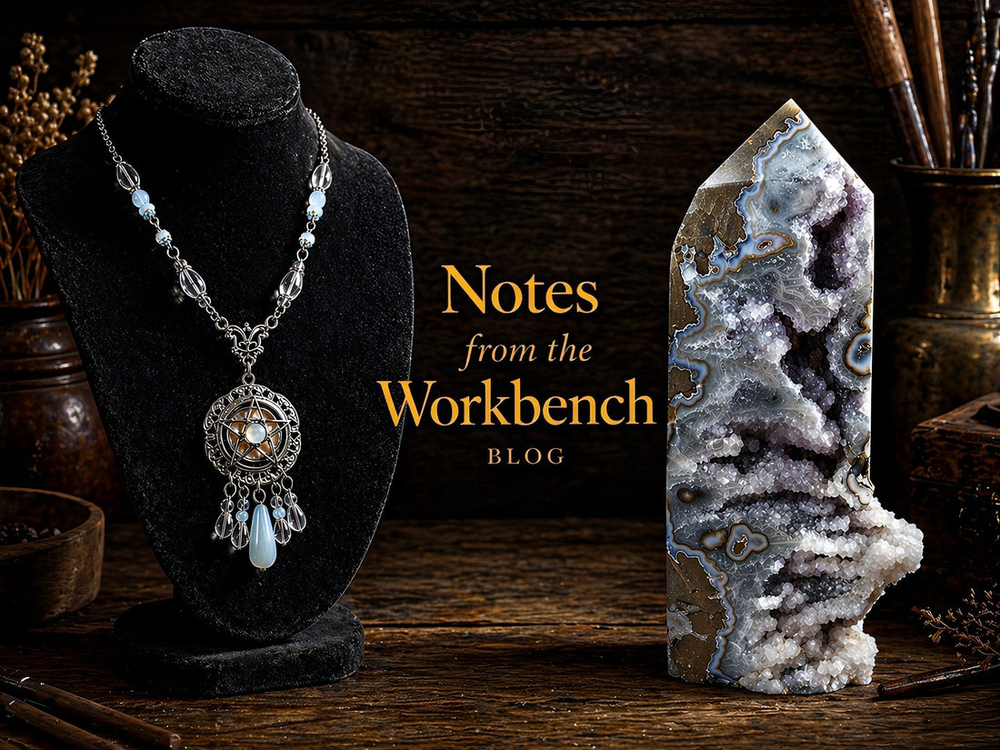 Moody workbench scene featuring a silver pendant necklace on a black display and a druzy agate tower, with “Notes from the Workbench” in gold lettering.